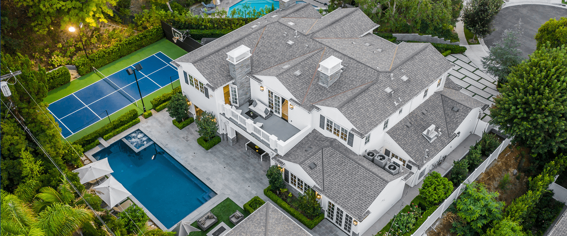 Aerial view of luxury home, pool, tennis court