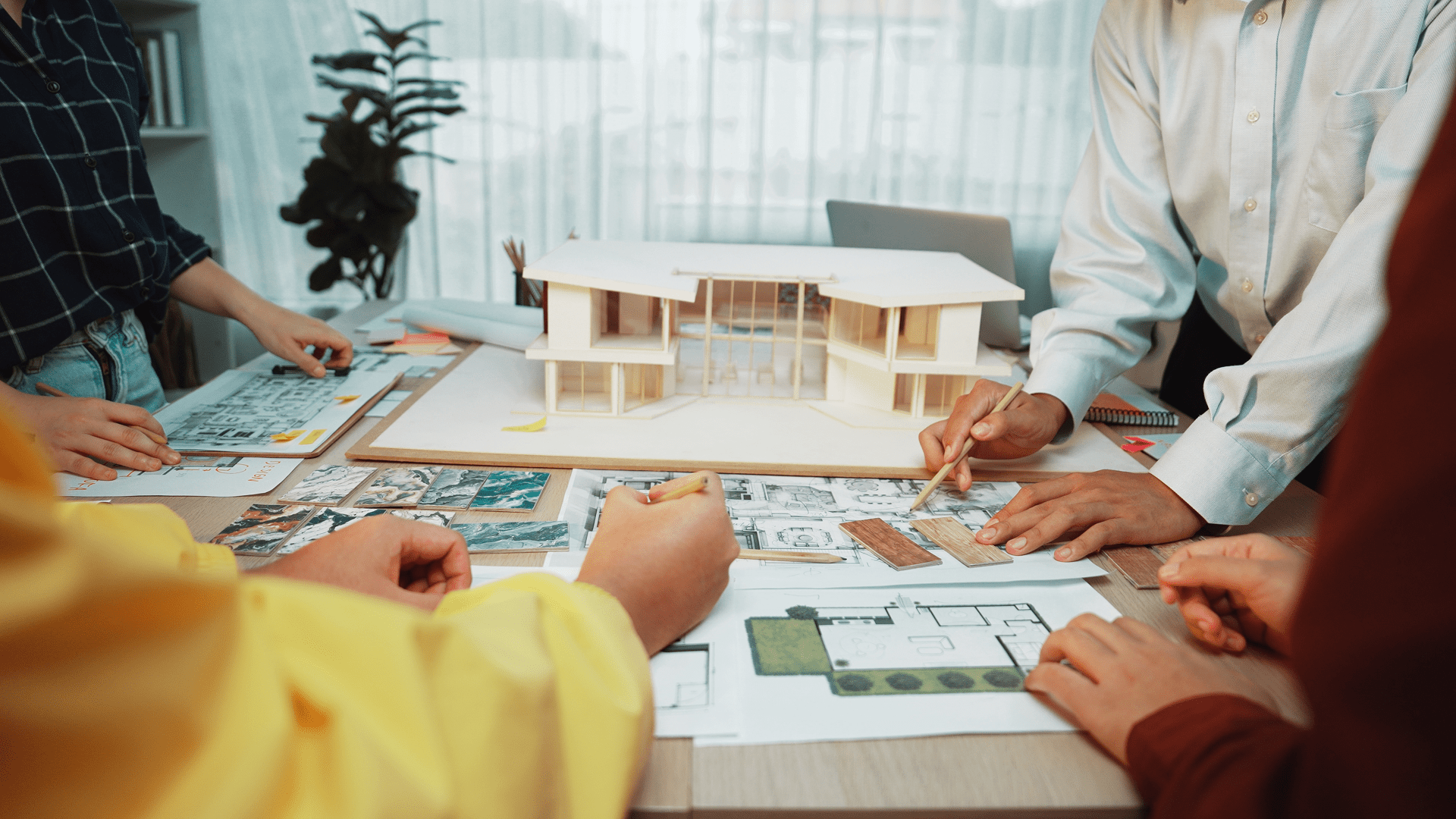 Team reviewing house model and blueprints