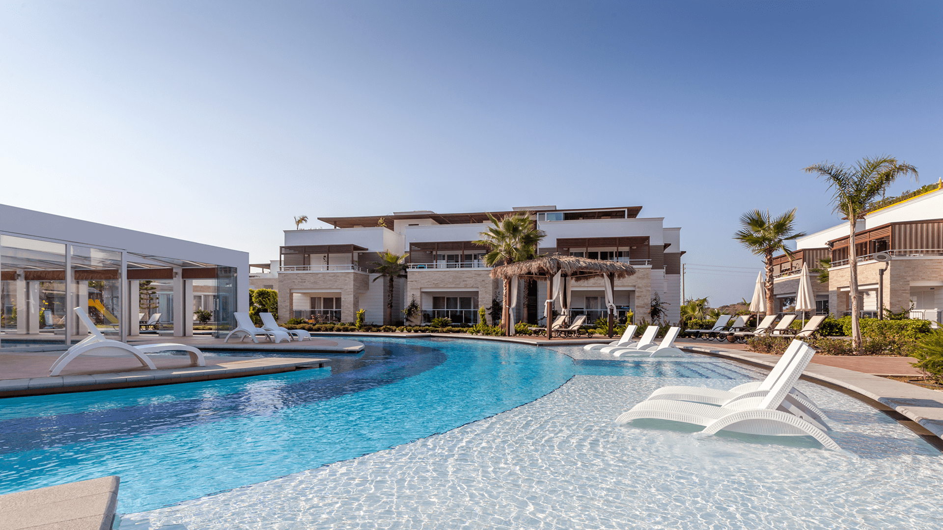 Resort pool with loungers and palm trees